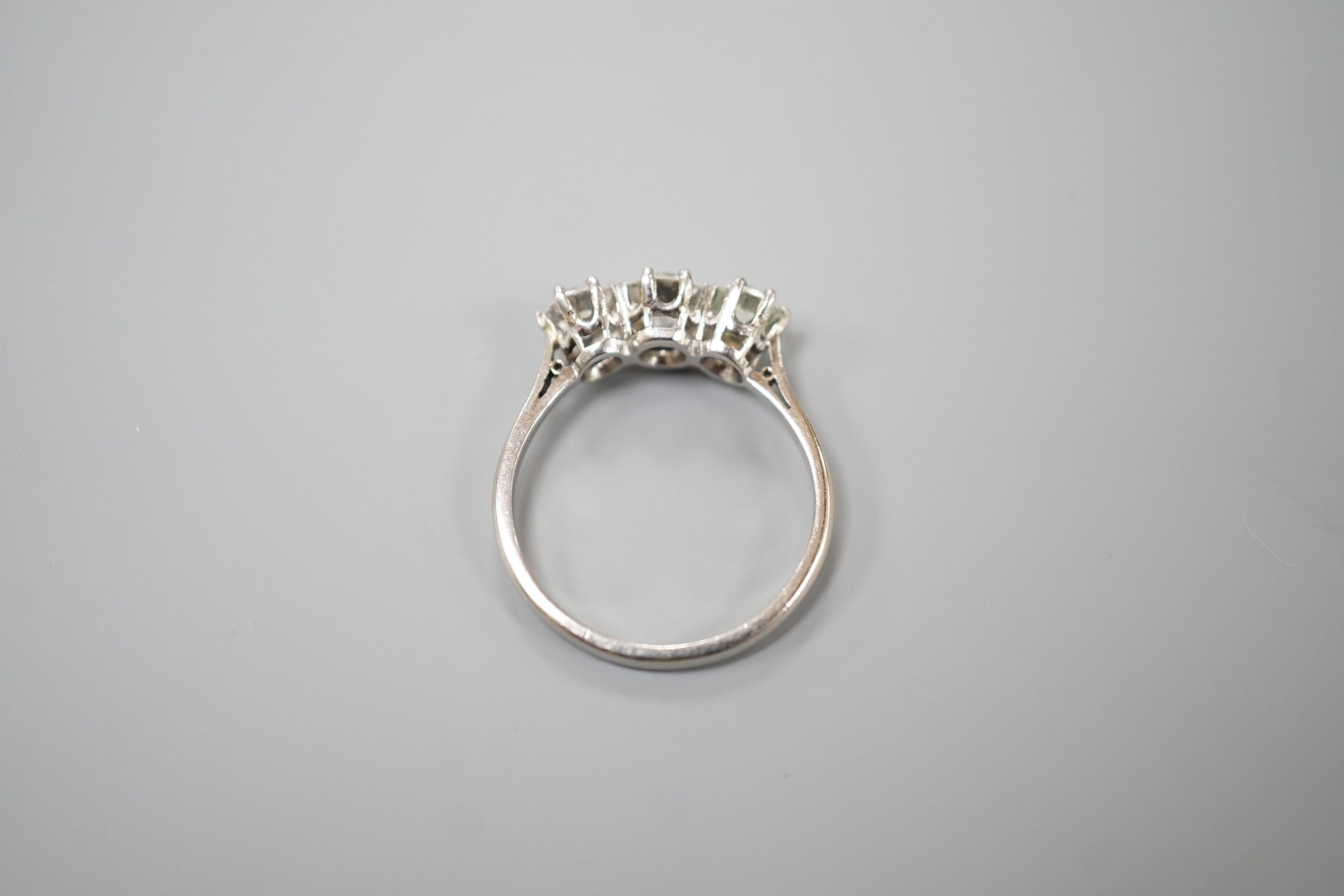 A white metal (stamped Plat) and three stone diamond set ring, size P/Q, gross weight 3.7 grams